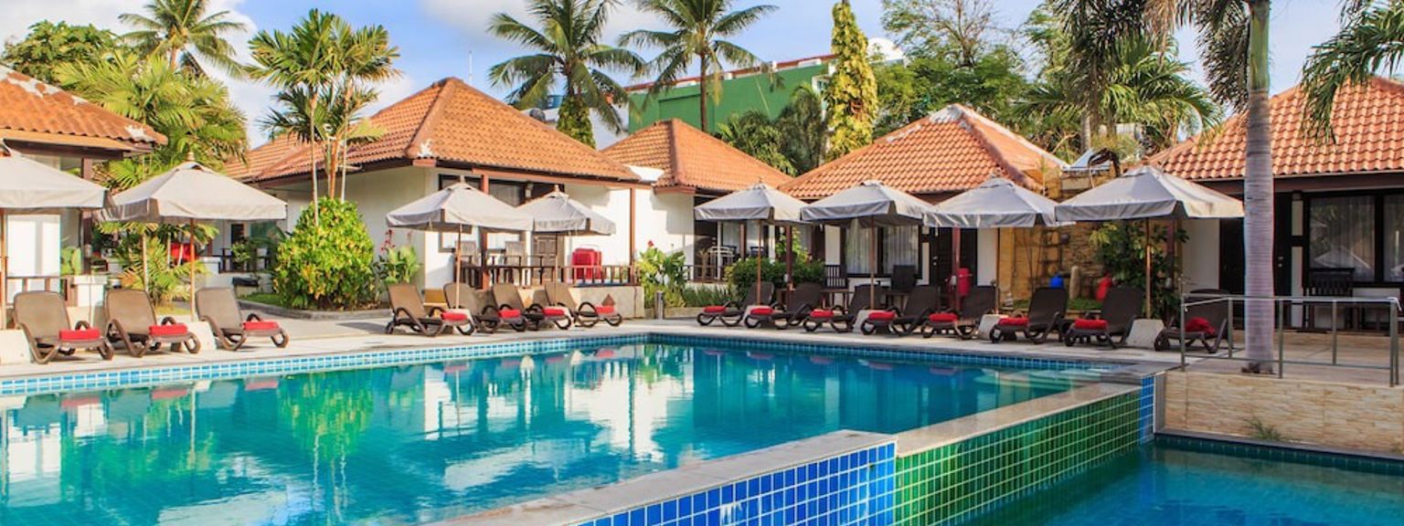en stor simbassäng omgiven av stolar och paraplyer på en resort