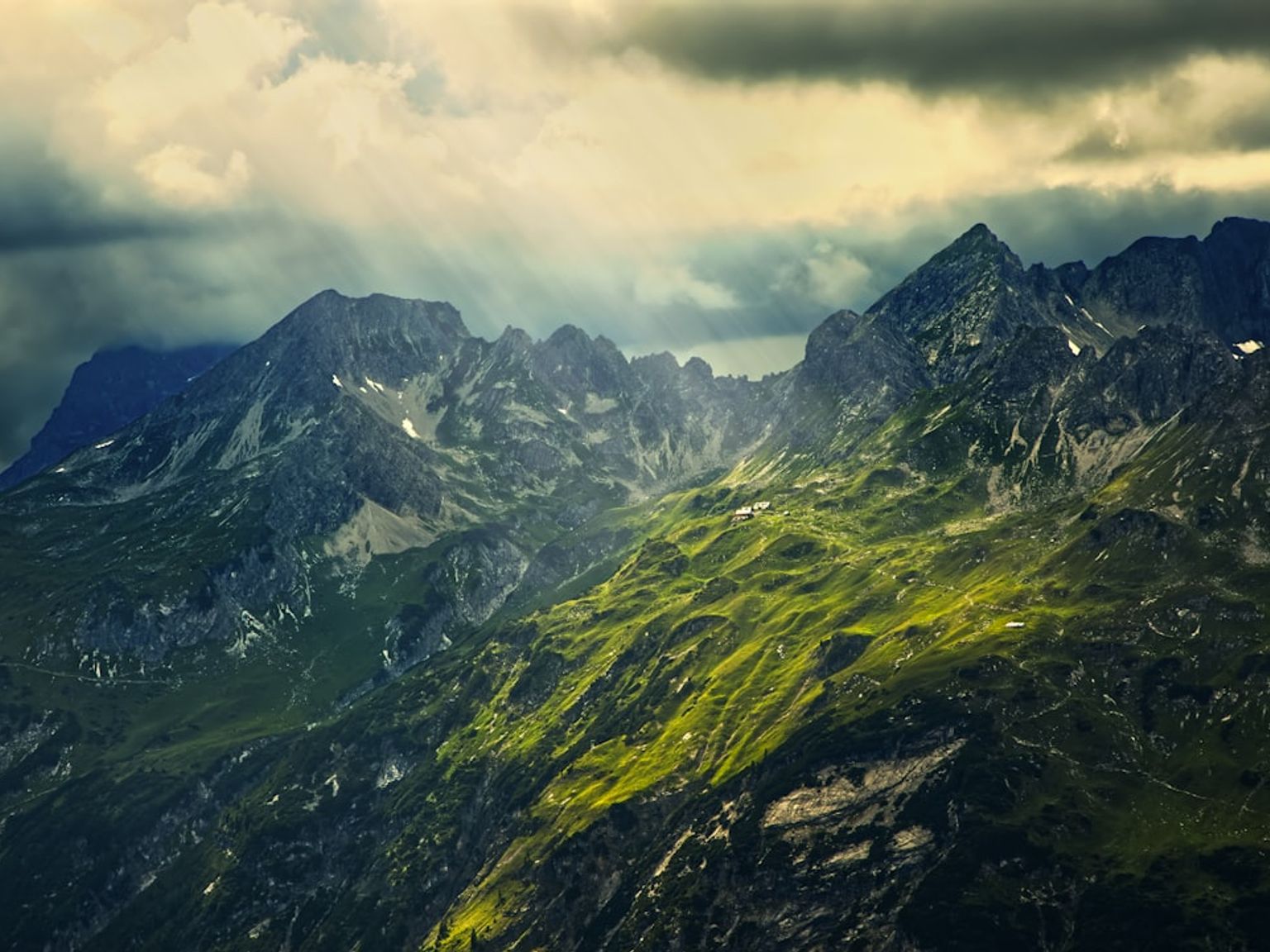 solen skiner genom molnen på bergen.