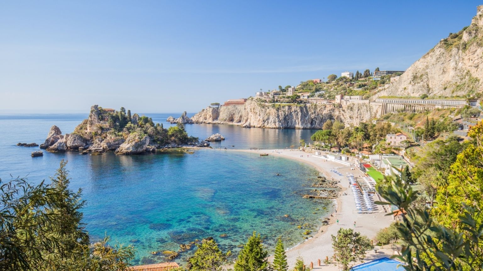 En strand i Taormina omgitt av trær