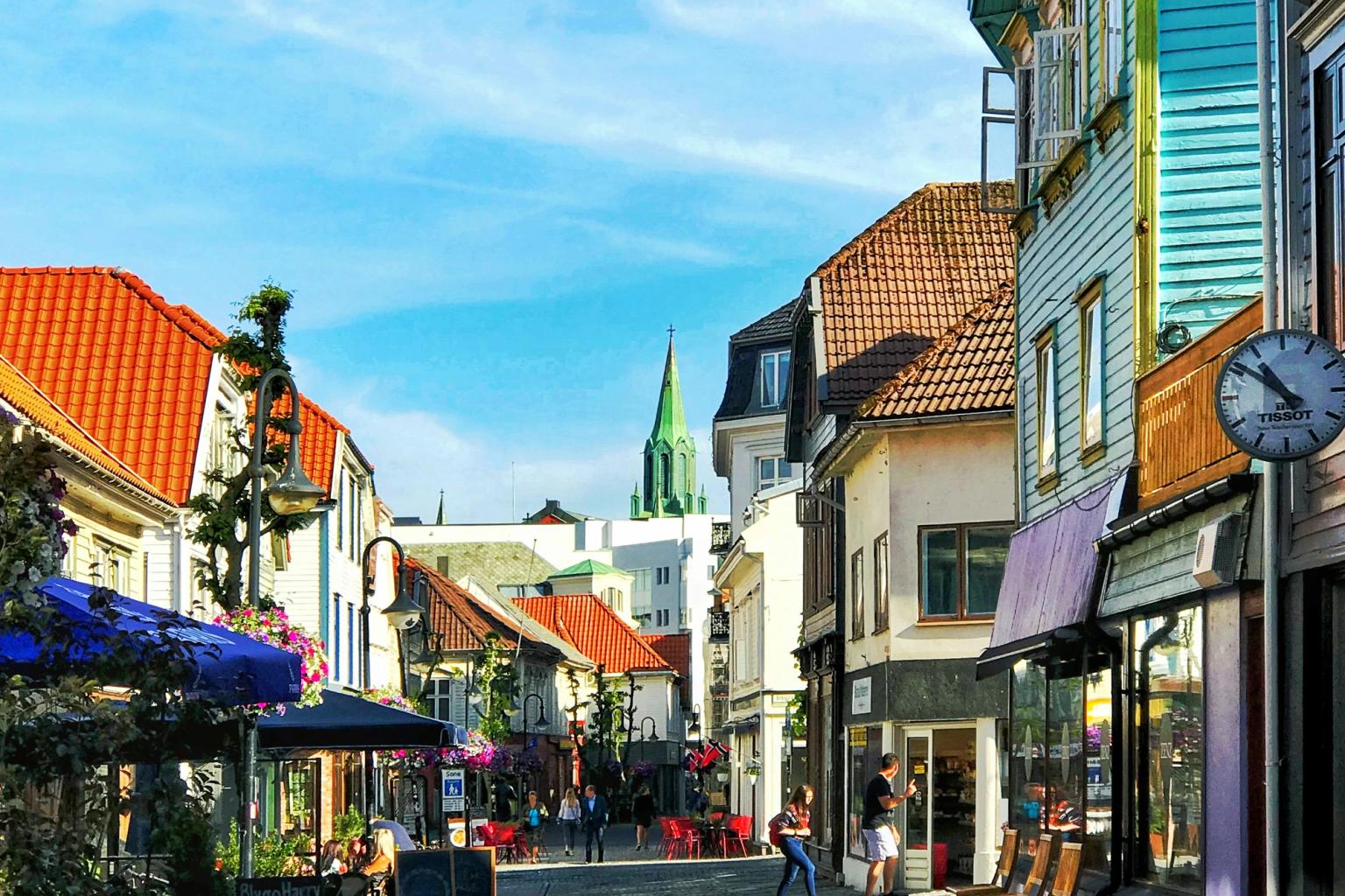 en brostensgade med et ur på siden af den