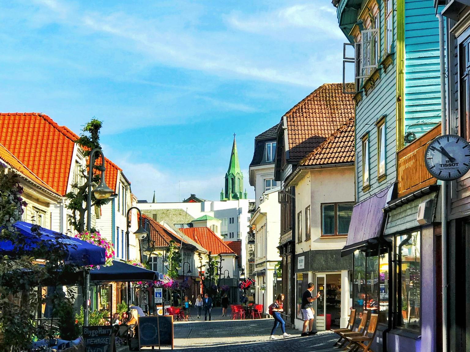 en brostensgade med et ur på siden af den