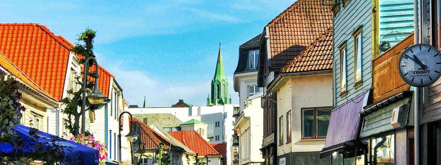 en brostensgade med et ur på siden af den