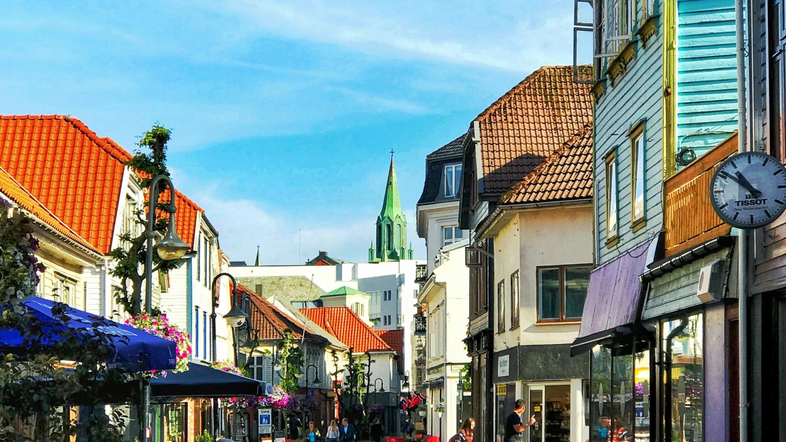 en brostensgade med et ur på siden af den