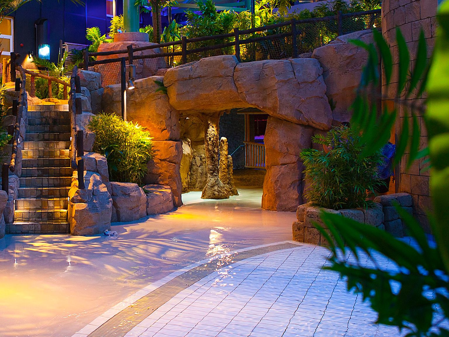 en trapp som fører til en hule i en vannpark om natten