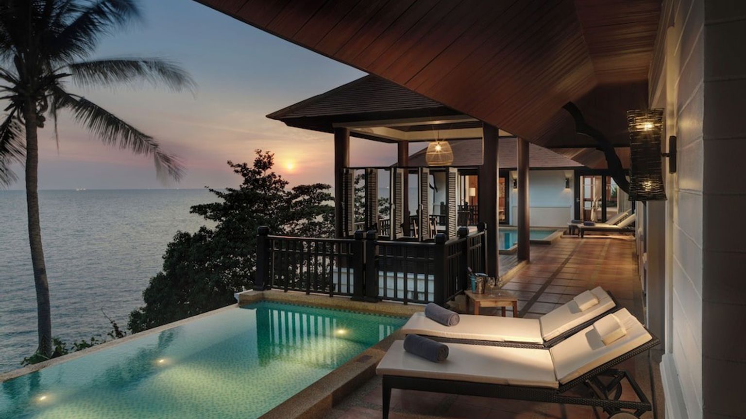 en villa med en pool med utsikt över havet vid solnedgången