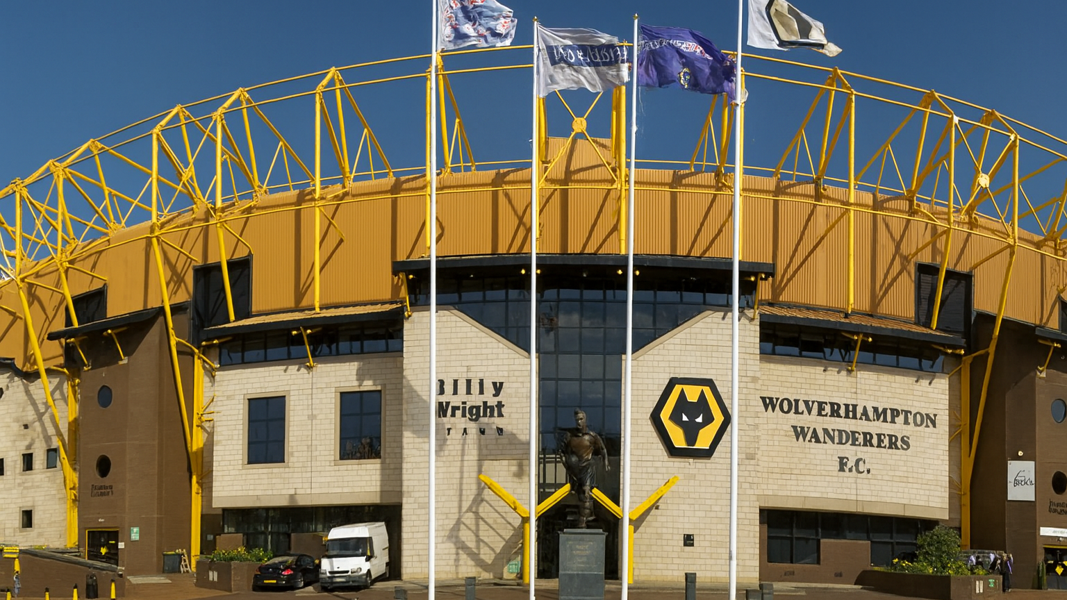 Wolverhampton Wanderers F.C. ulvehode-logo og klubbnavn på en beige murbygning.