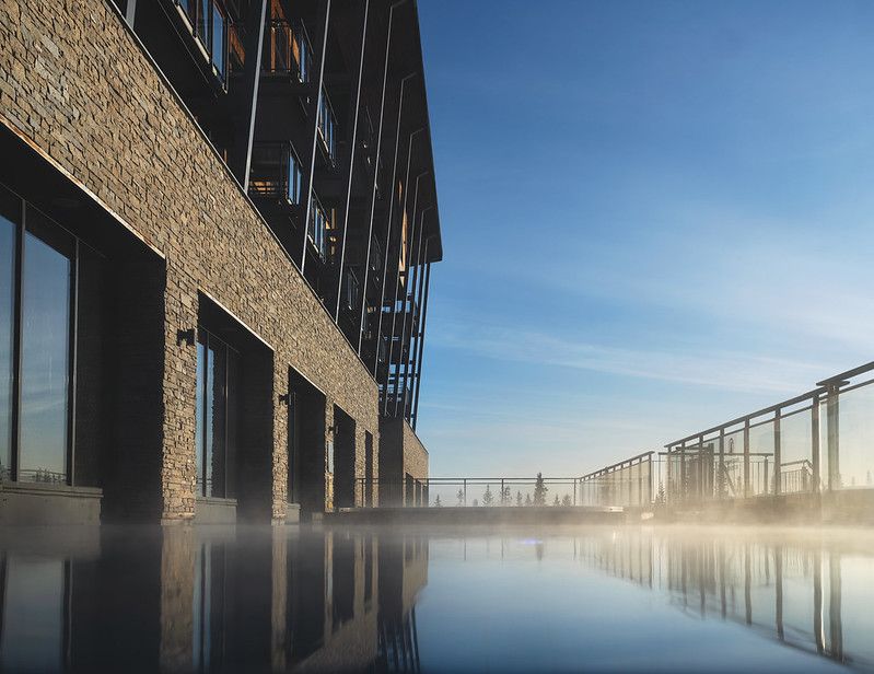 en stor byggnad med en swimmingpool framför den