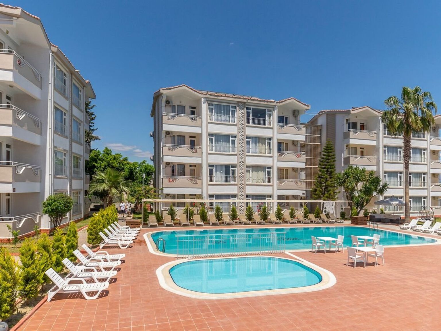 en stor simbassÀng omgiven av stolar och bord framför en byggnad