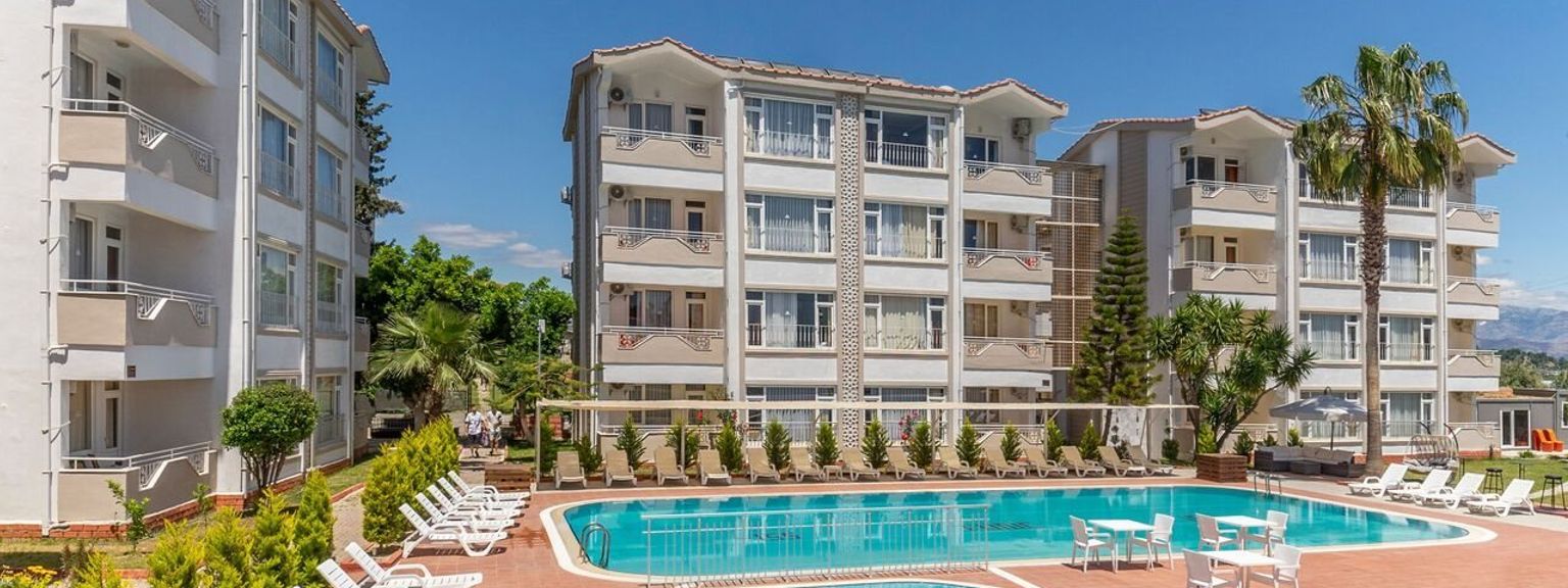 en stor simbassÀng omgiven av stolar och bord framför en byggnad