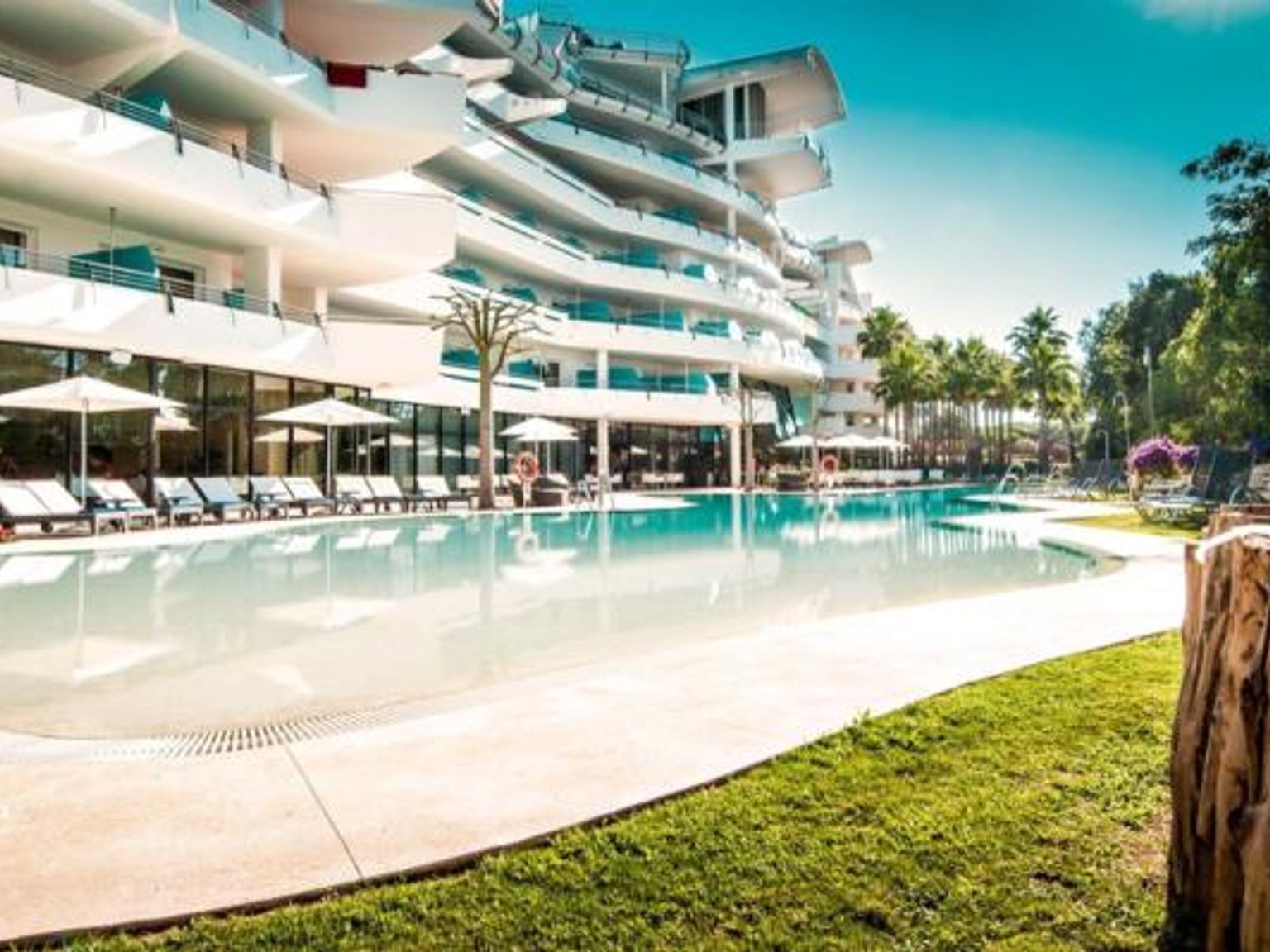 det er et stort svømmebasseng foran et hotell
