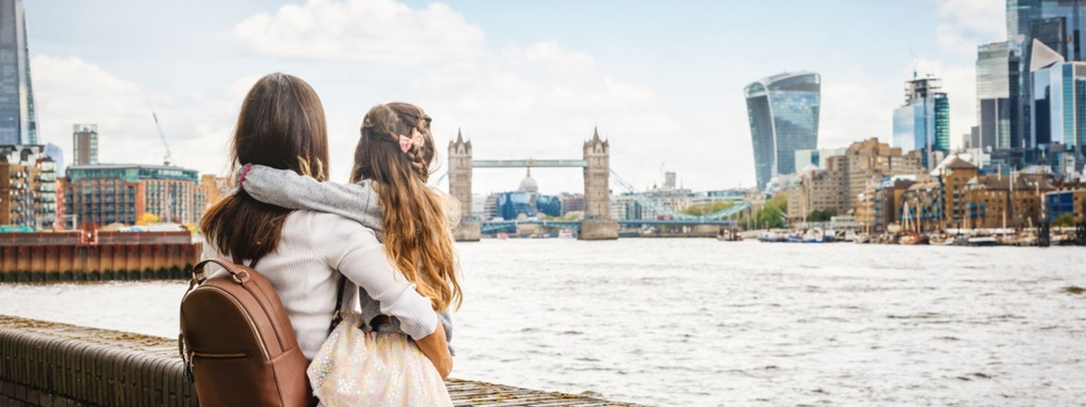 en kvinne og en liten jente ser på Themsen i London.