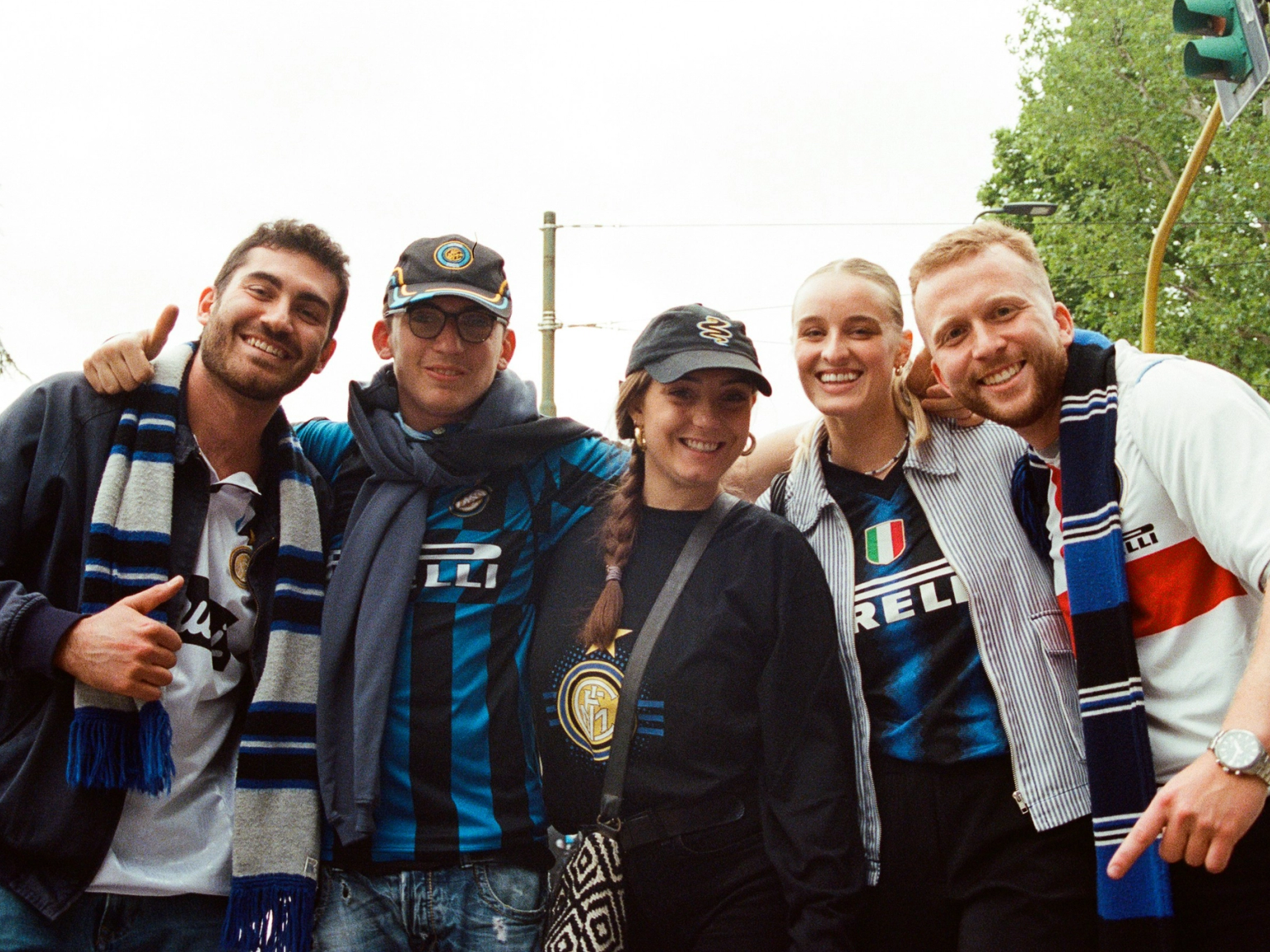 Five smiling friends posing in Inter Milan jerseys and scarves.
