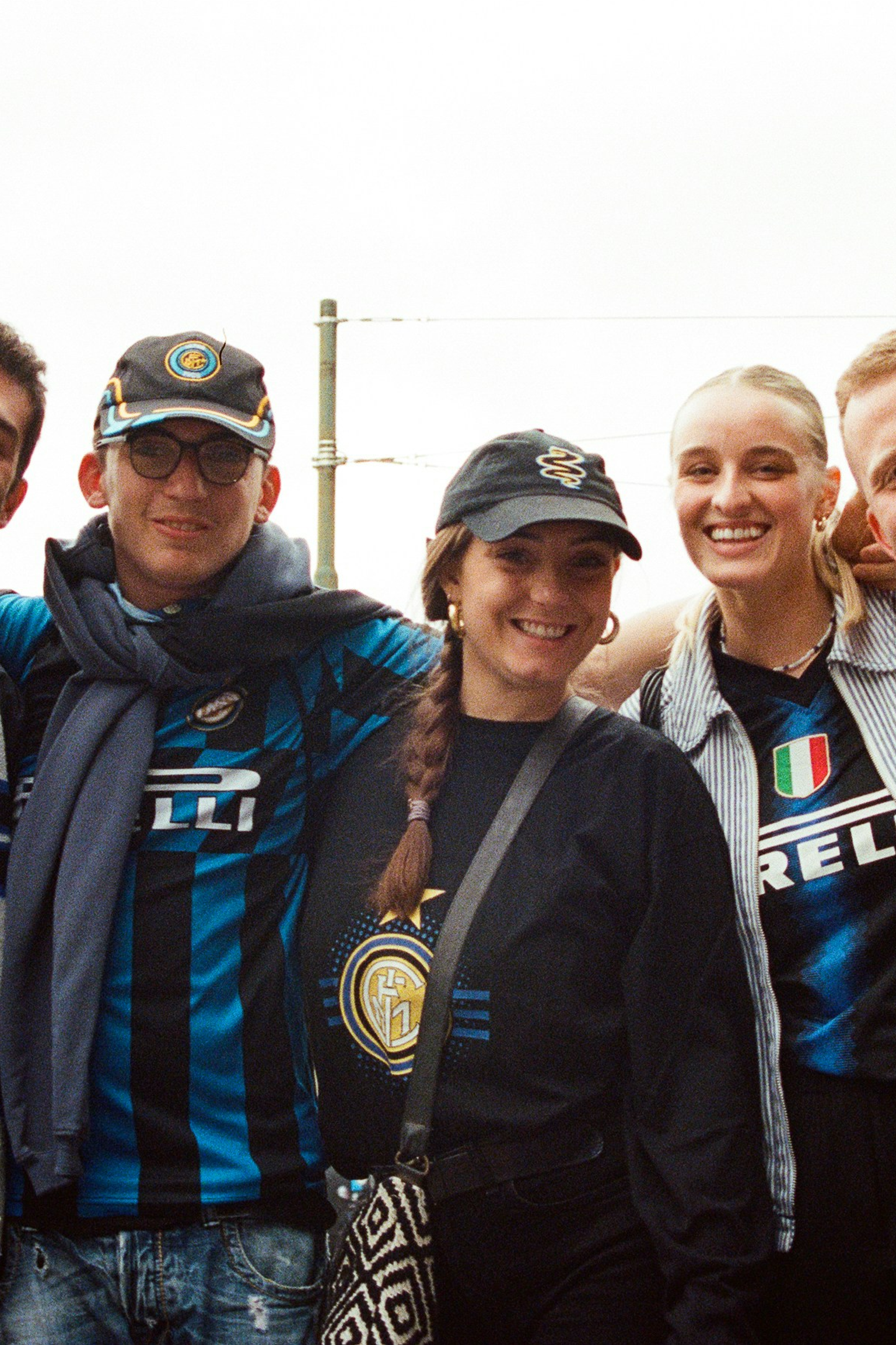 Five smiling friends posing in Inter Milan jerseys and scarves.