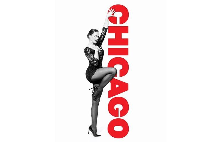 Schwarz-weiß-Bild einer Frau in einem schwarzen Kleid und High Heels, die neben einem vertikalen roten "CHICAGO"-Schriftzug posiert, wobei ihre Hand den Buchstaben "C" berührt und ihr Knie auf dem "A" ruht.