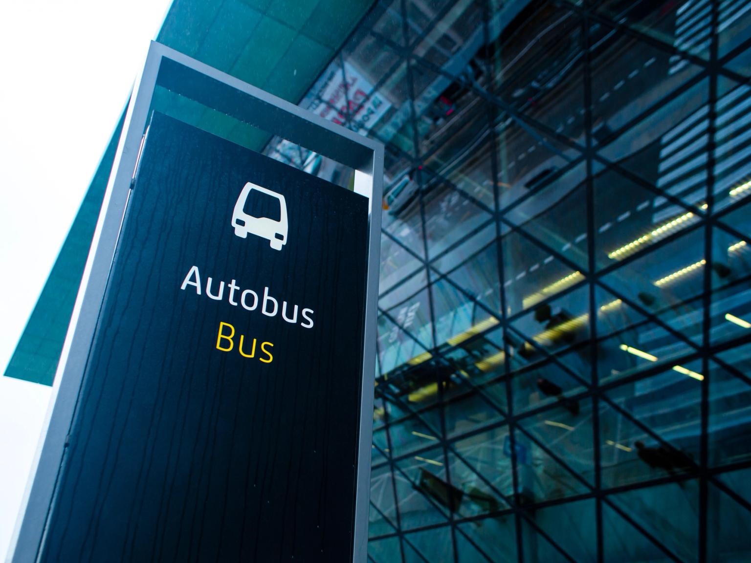 et busskilt er foran en glassbygning