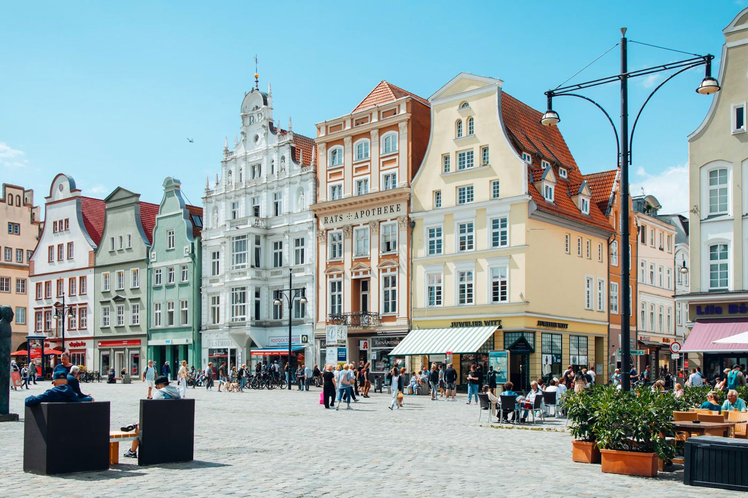 en byplass fylt med mange bygninger og mennesker på en solrik dag