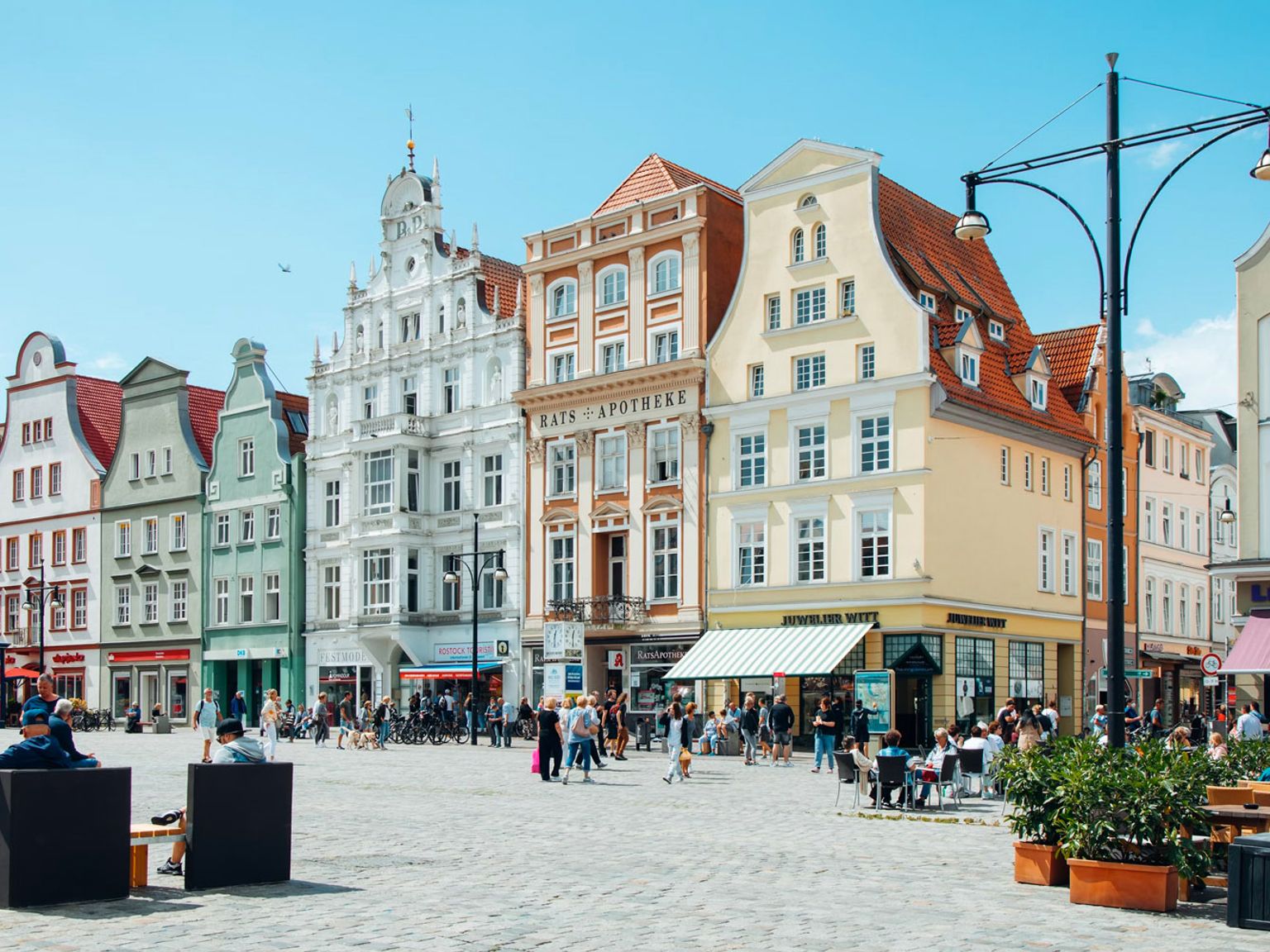 en byplass fylt med mange bygninger og mennesker på en solrik dag