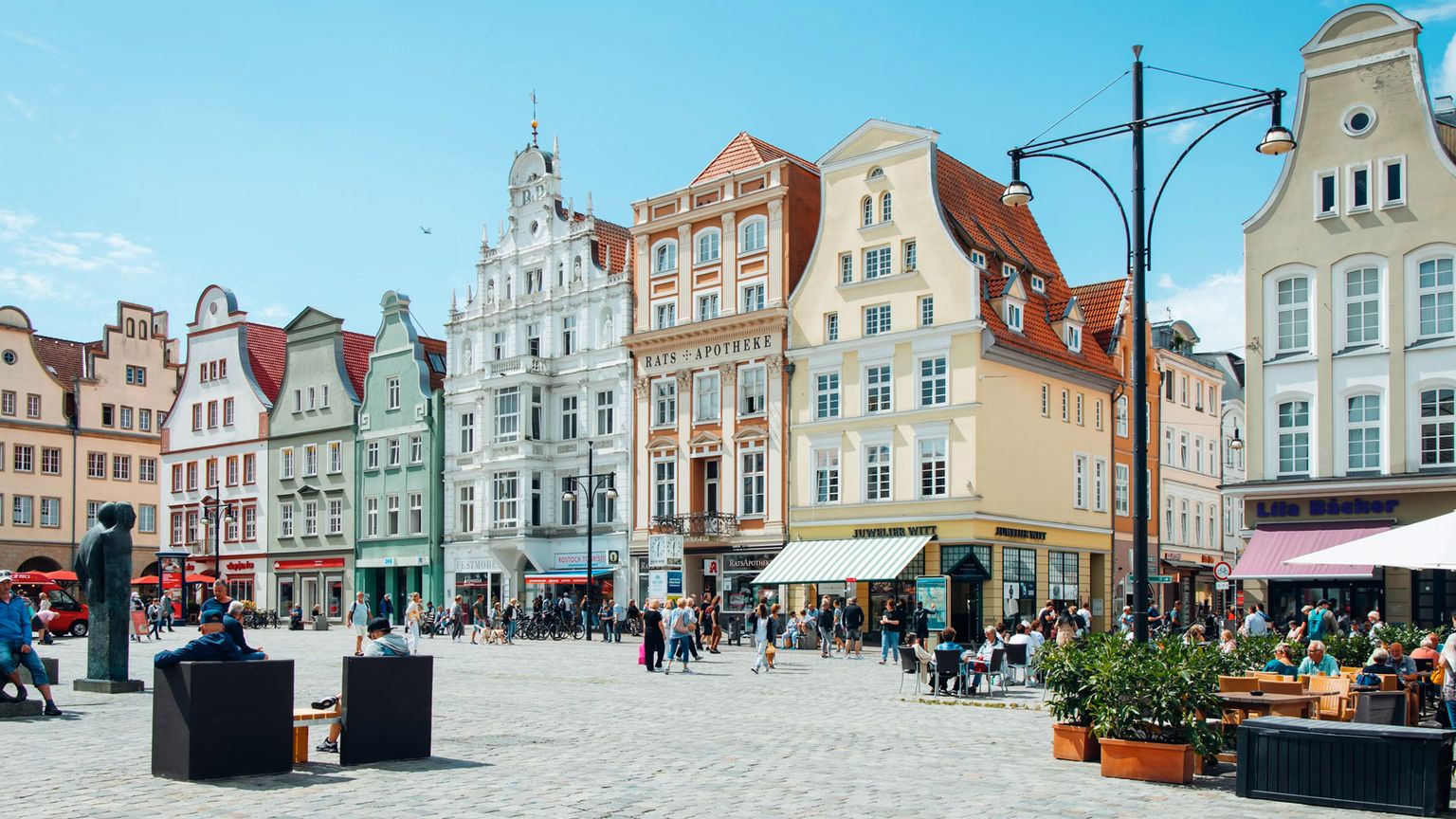 en byplass fylt med mange bygninger og mennesker på en solrik dag
