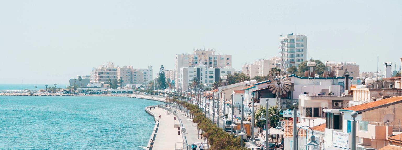 et par mennesker, der går på en fortov ved siden af havet