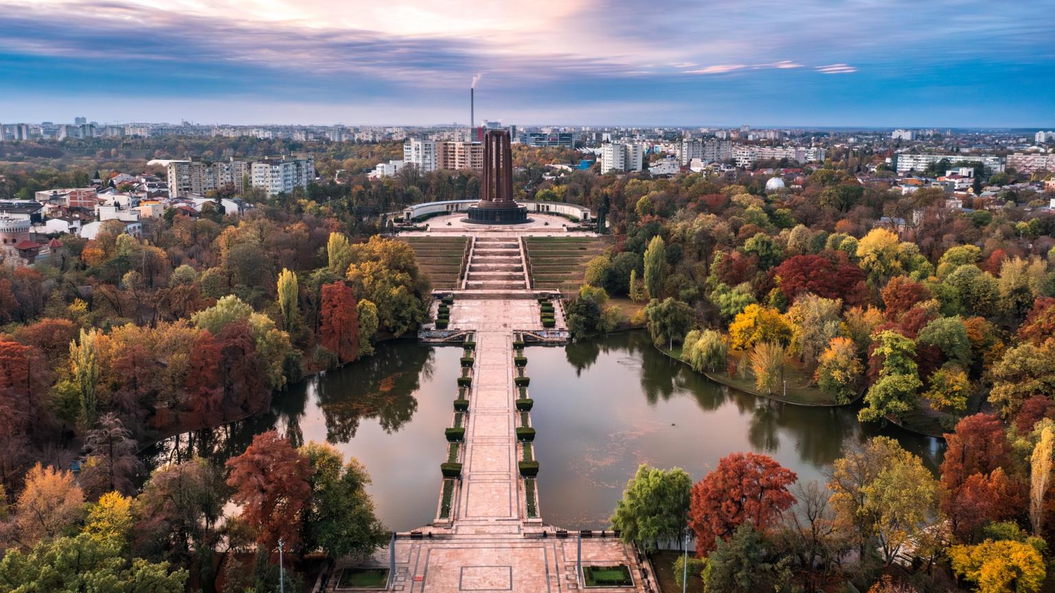 en luftvisning af en park med en sø og træer om efteråret