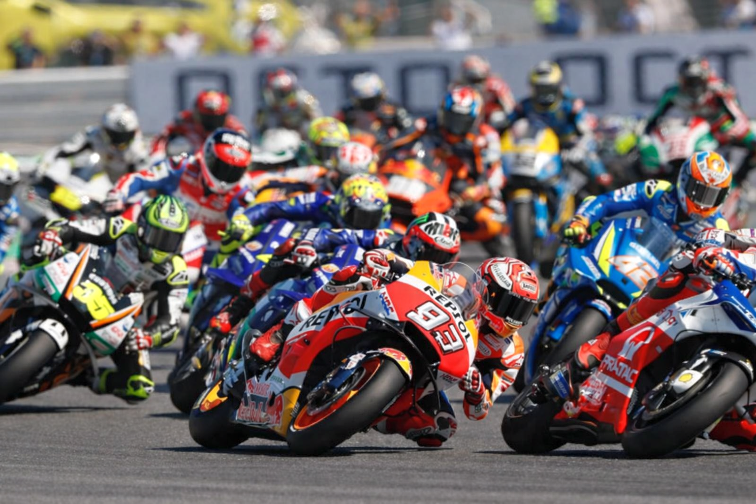 Ryhmä motoripyöräilijöitä kallistumassa mutkaan kilpailun aikana.