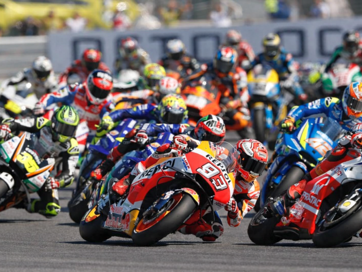 Ryhmä motoripyöräilijöitä kallistumassa mutkaan kilpailun aikana.