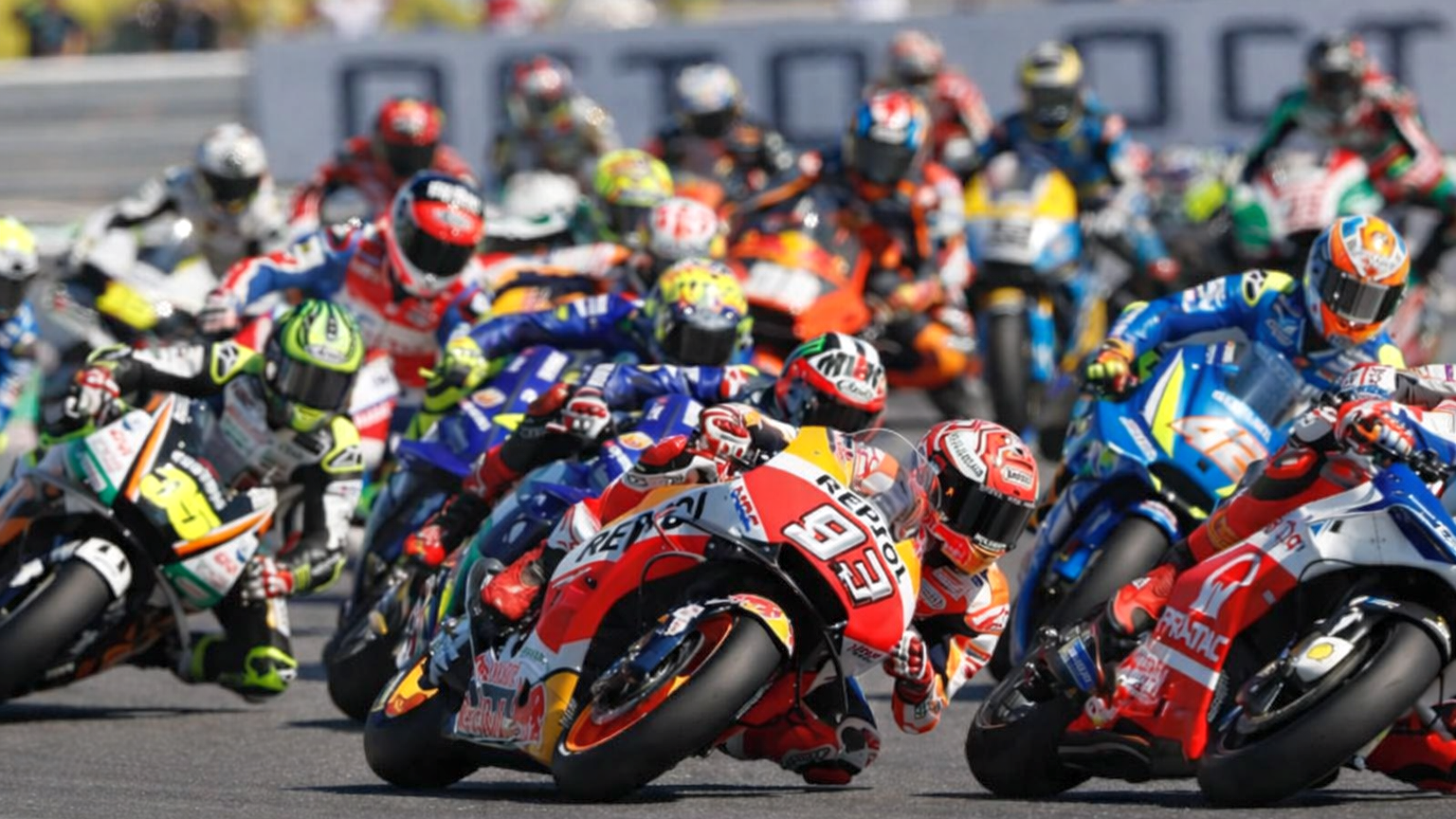 Un grupo de motociclistas inclinándose en una curva durante una carrera.