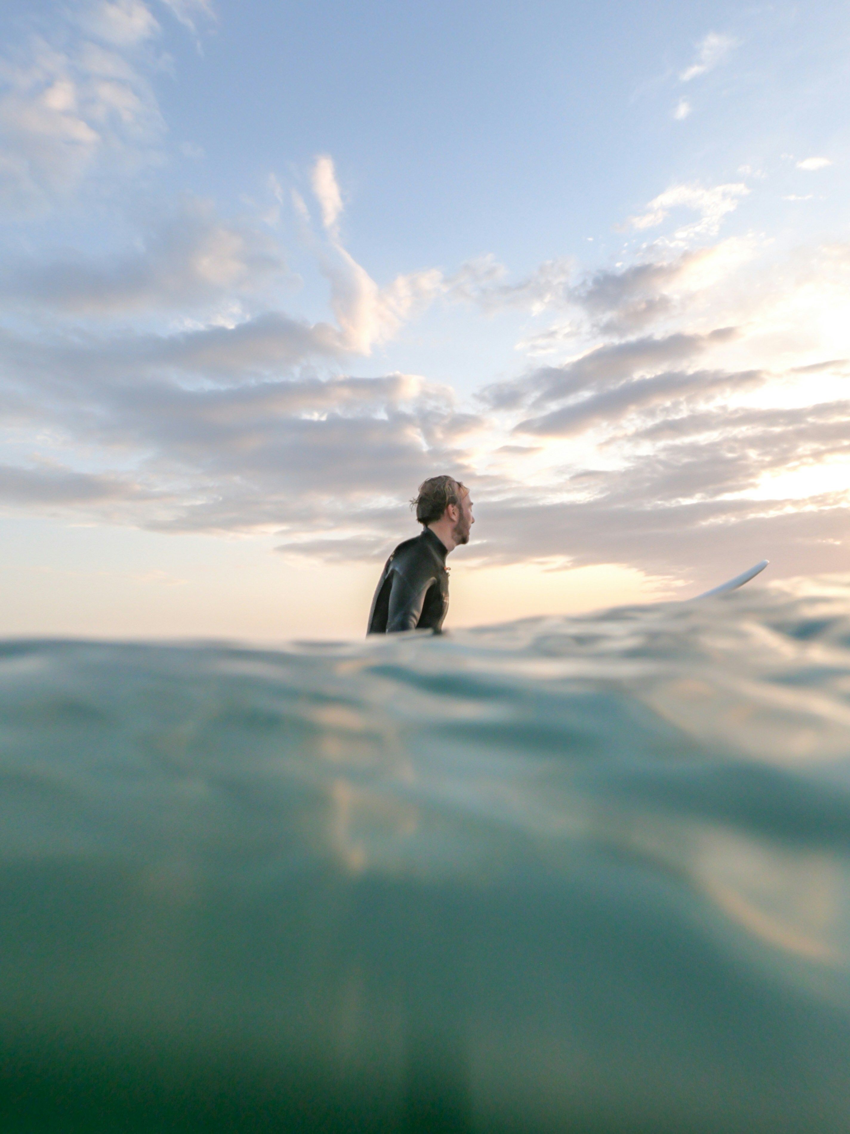 a man in a wetsuit is holding a surfboard in the ocean
