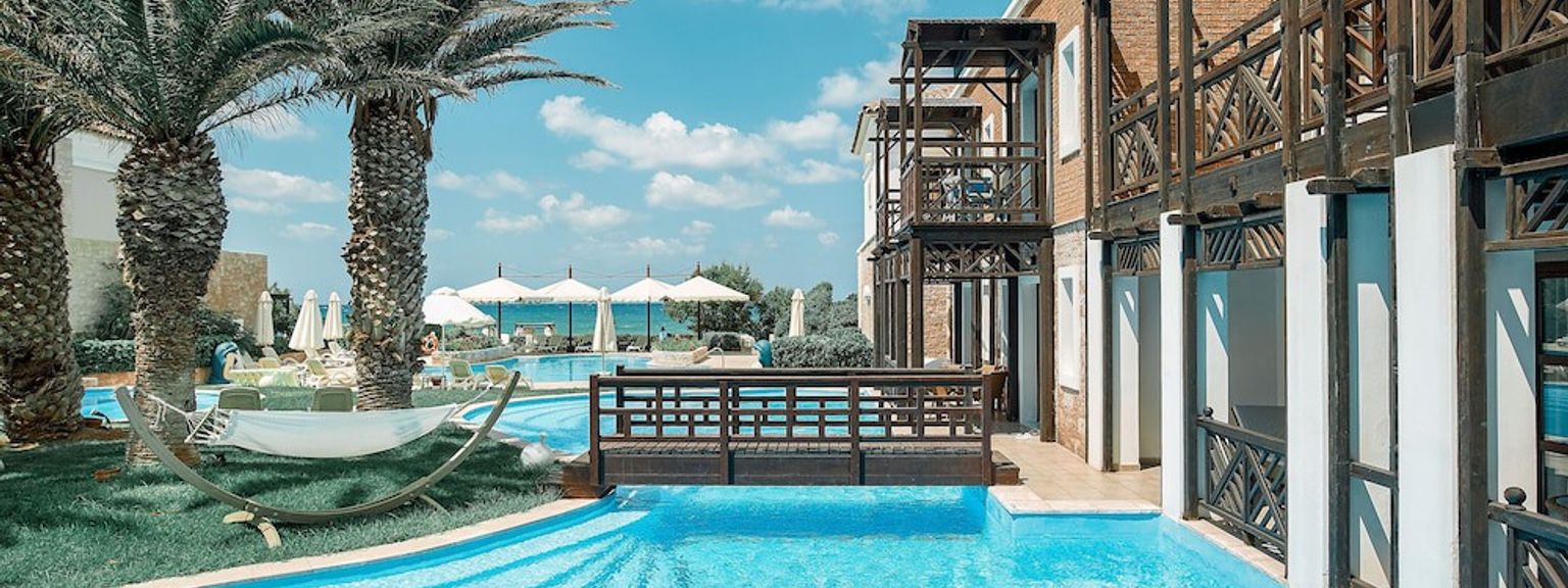 ein großer Swimmingpool umgeben von Palmen und einer Brücke