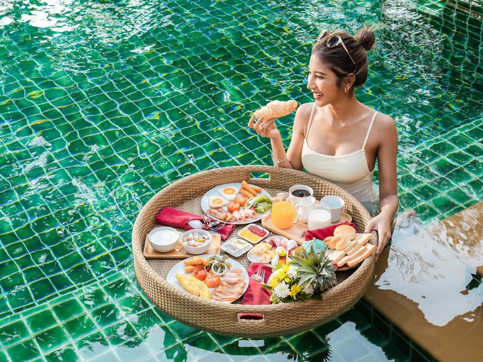 eine Frau isst Frühstück in einem Schwimmbecken