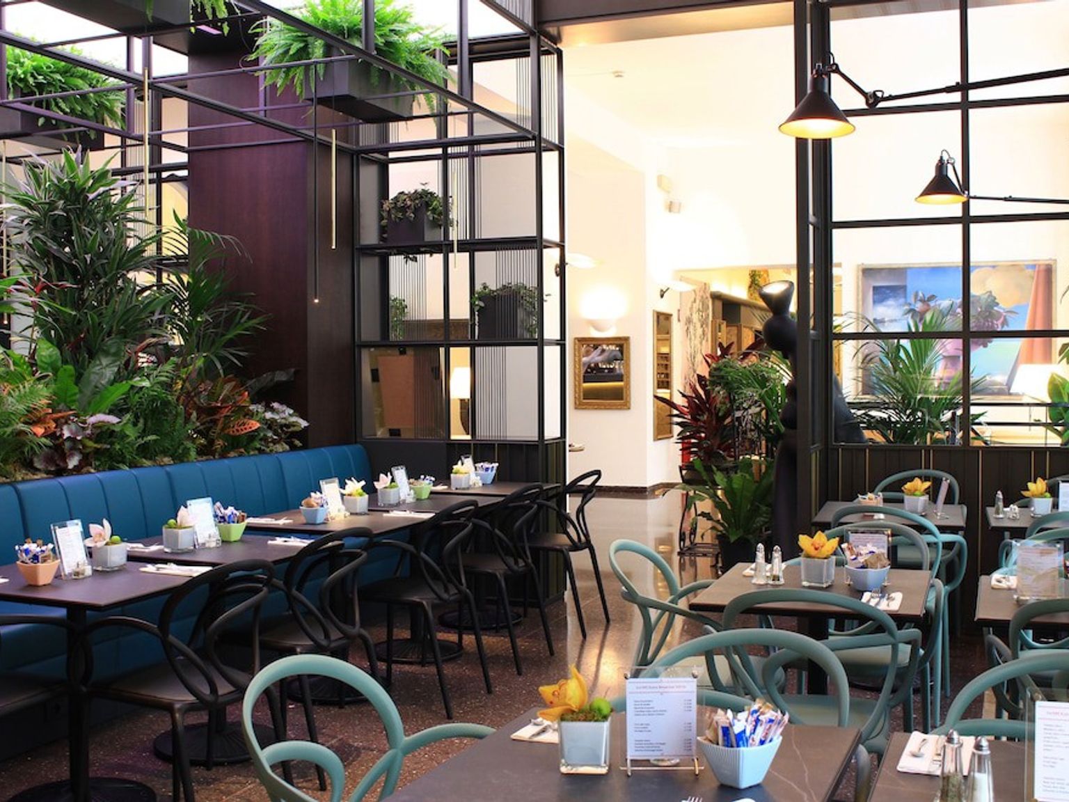 en restaurant fylt med bord og stoler og planter
