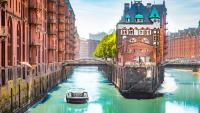 ein Boot schwimmt auf einem Fluss in einer Stadt. Hamburg