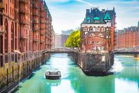 ein Boot schwimmt auf einem Fluss in einer Stadt. Hamburg
