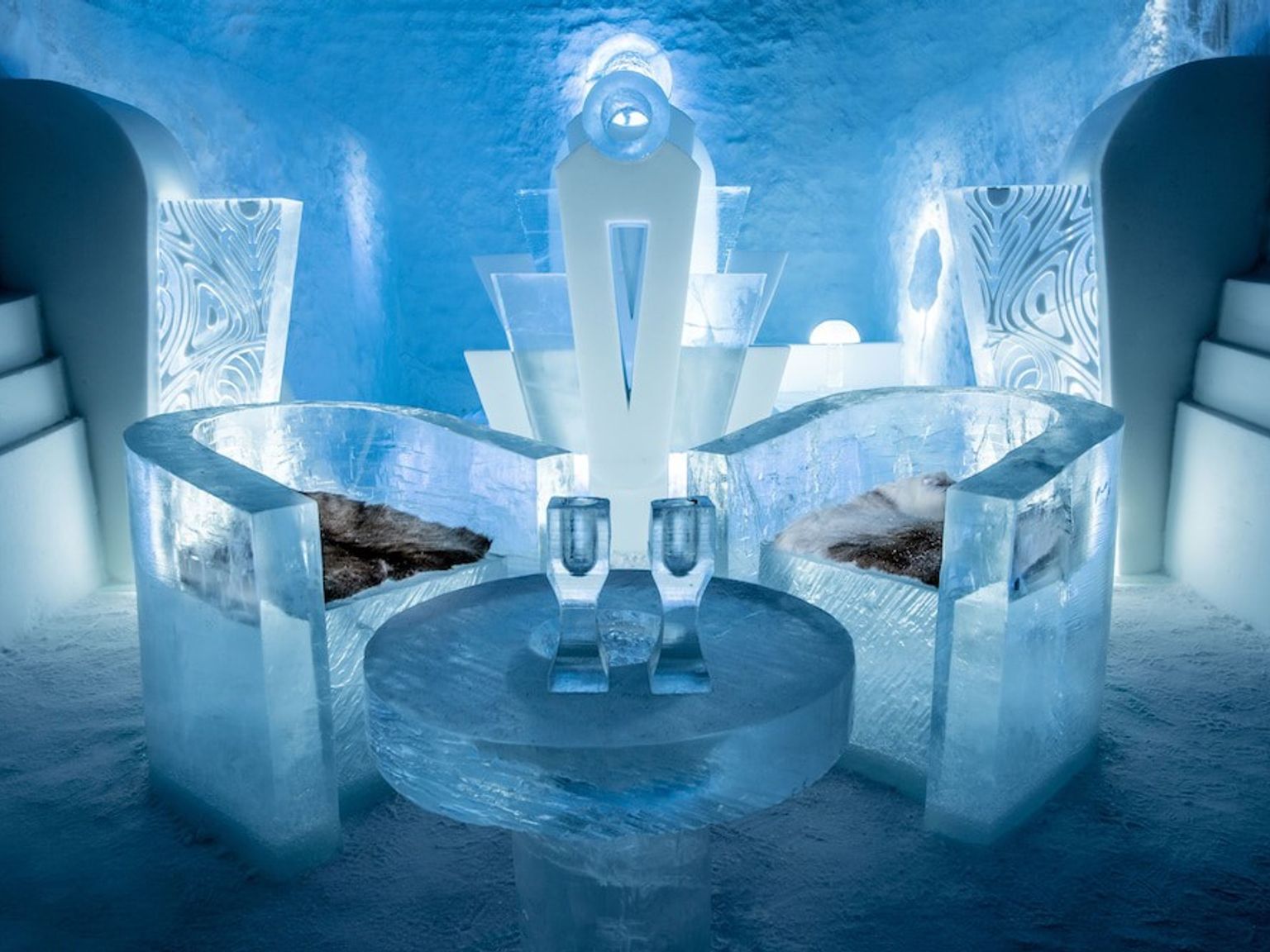 una habitación hecha de hielo con una mesa y sillas hechas de hielo