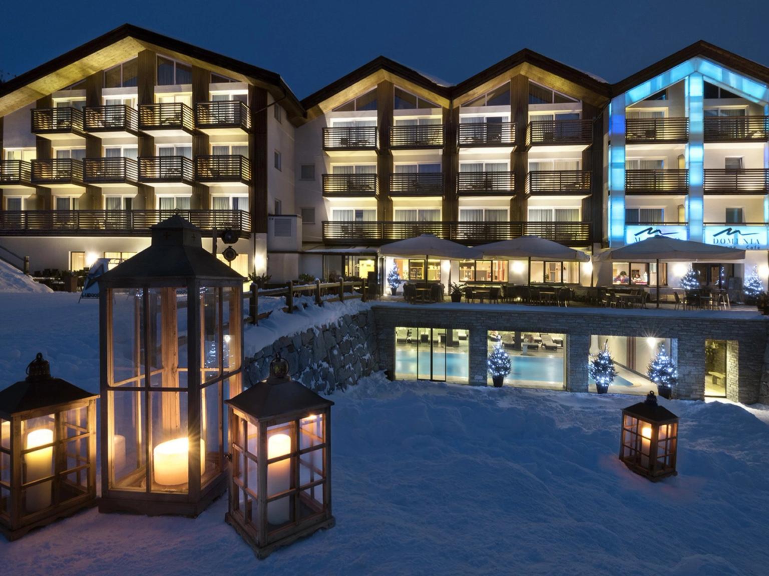 et stort hotell er opplyst om natten med lanterner foran, Hotel Lac Salin Spa & Mountain Resort, Livigno