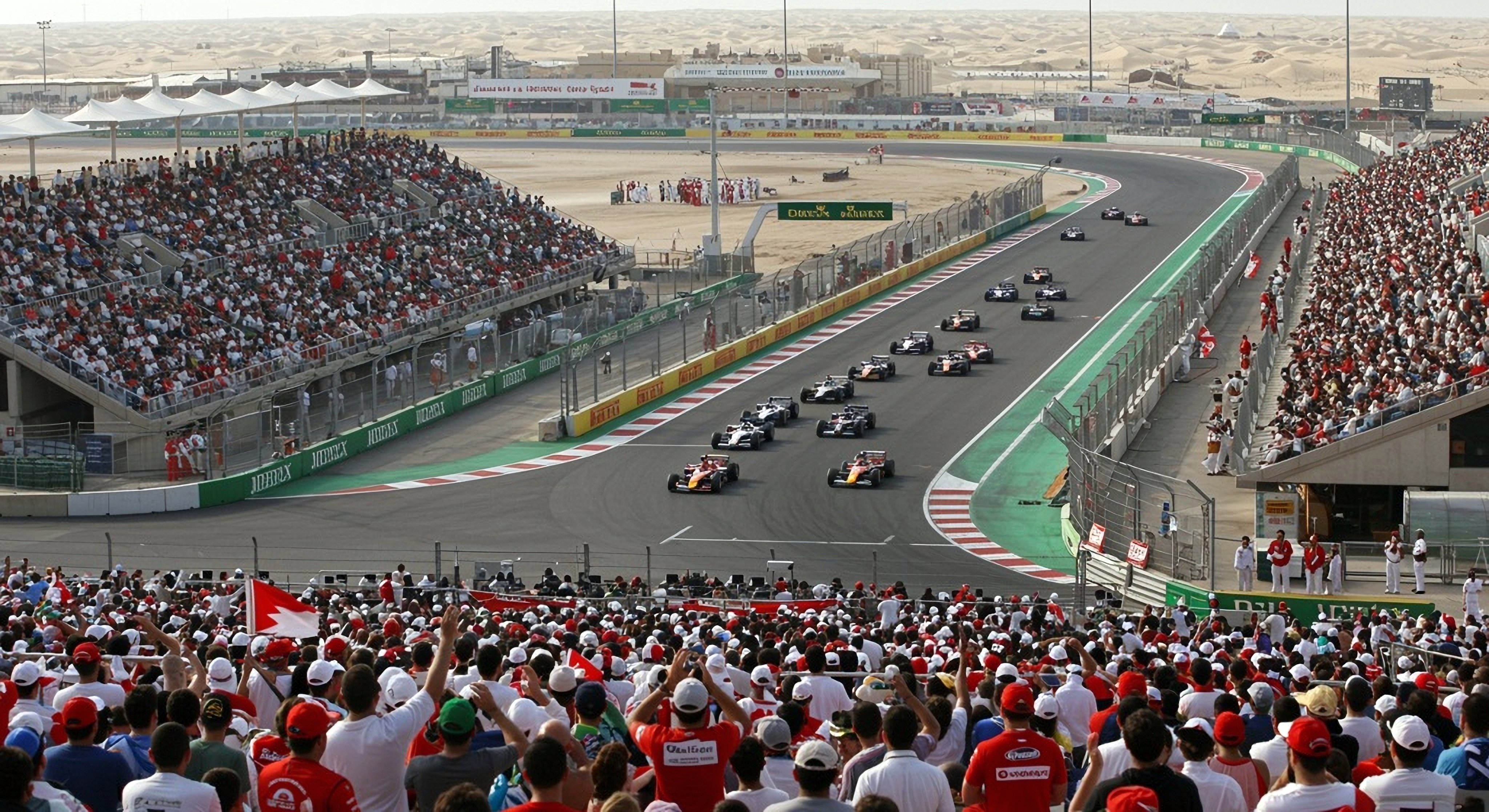 Avo-ohjaamolliset kilpa-autot aavikkoradalla, katsomot täynnä katsojia.