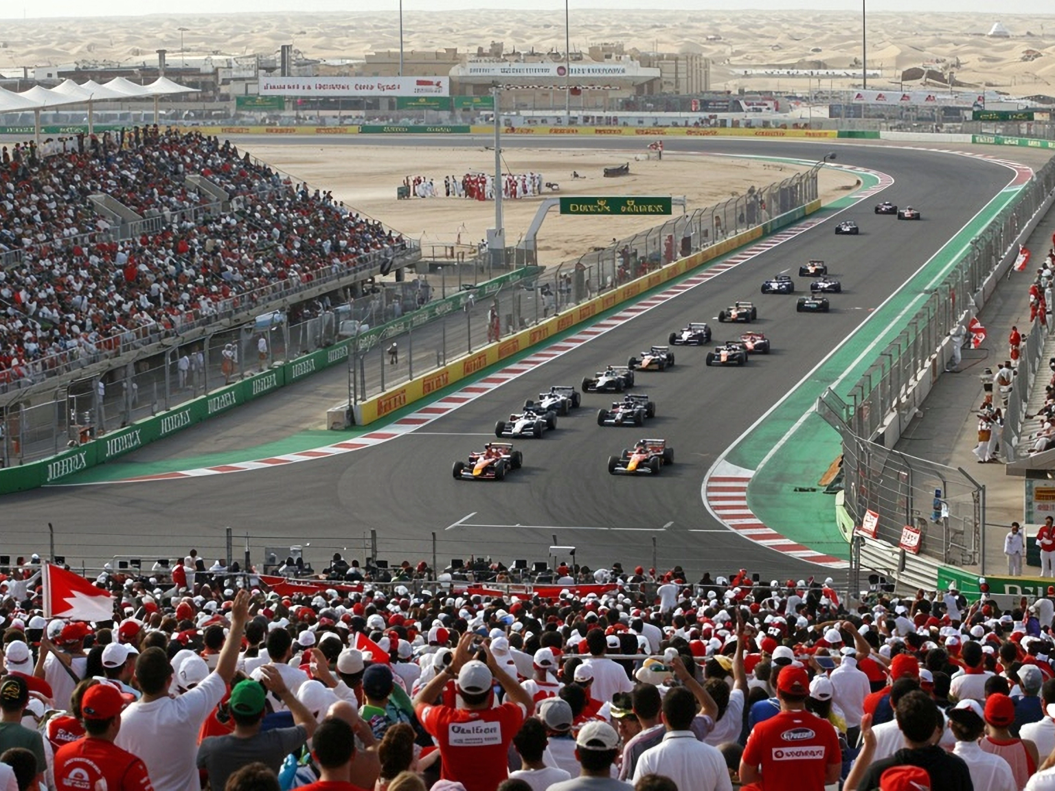 Avo-ohjaamolliset kilpa-autot aavikkoradalla, katsomot täynnä katsojia.