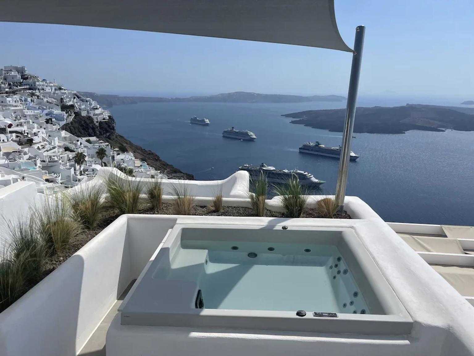 det er et boblebad på taket av en bygning med utsikt over havet.