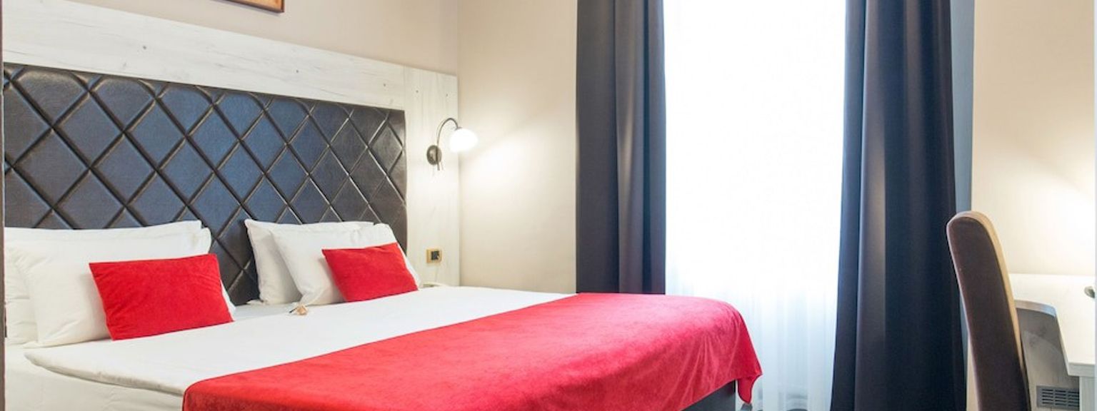 ett hotellrum med en stor säng och ett skrivbord