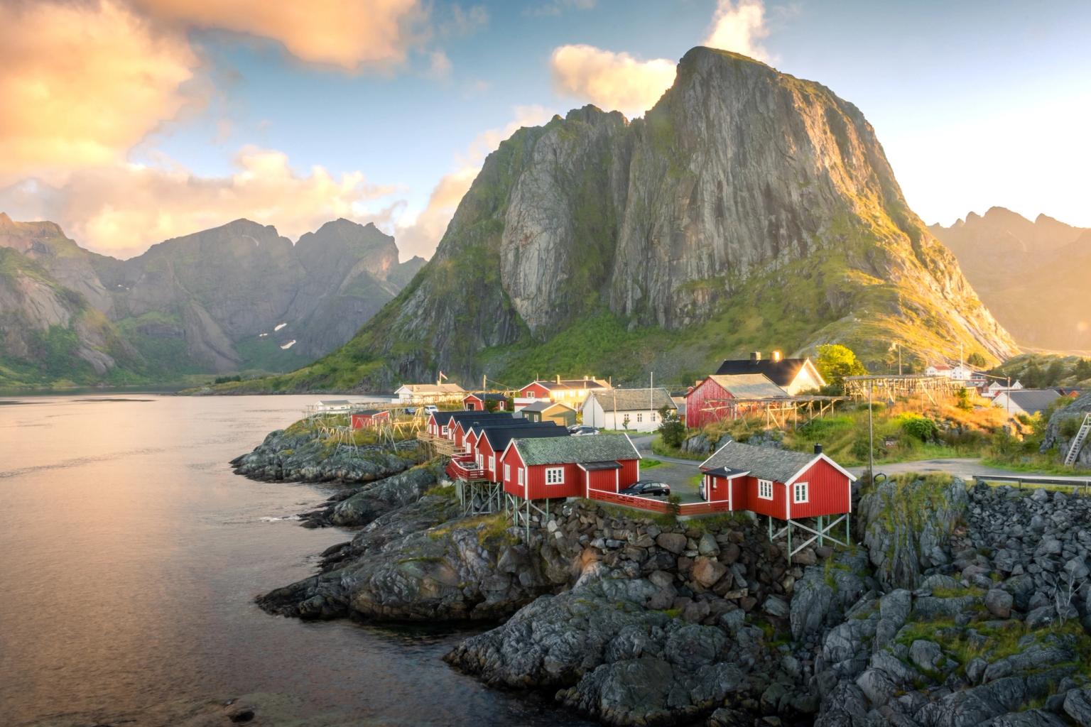 a small village in the mountains with red houses and a mountain in the background