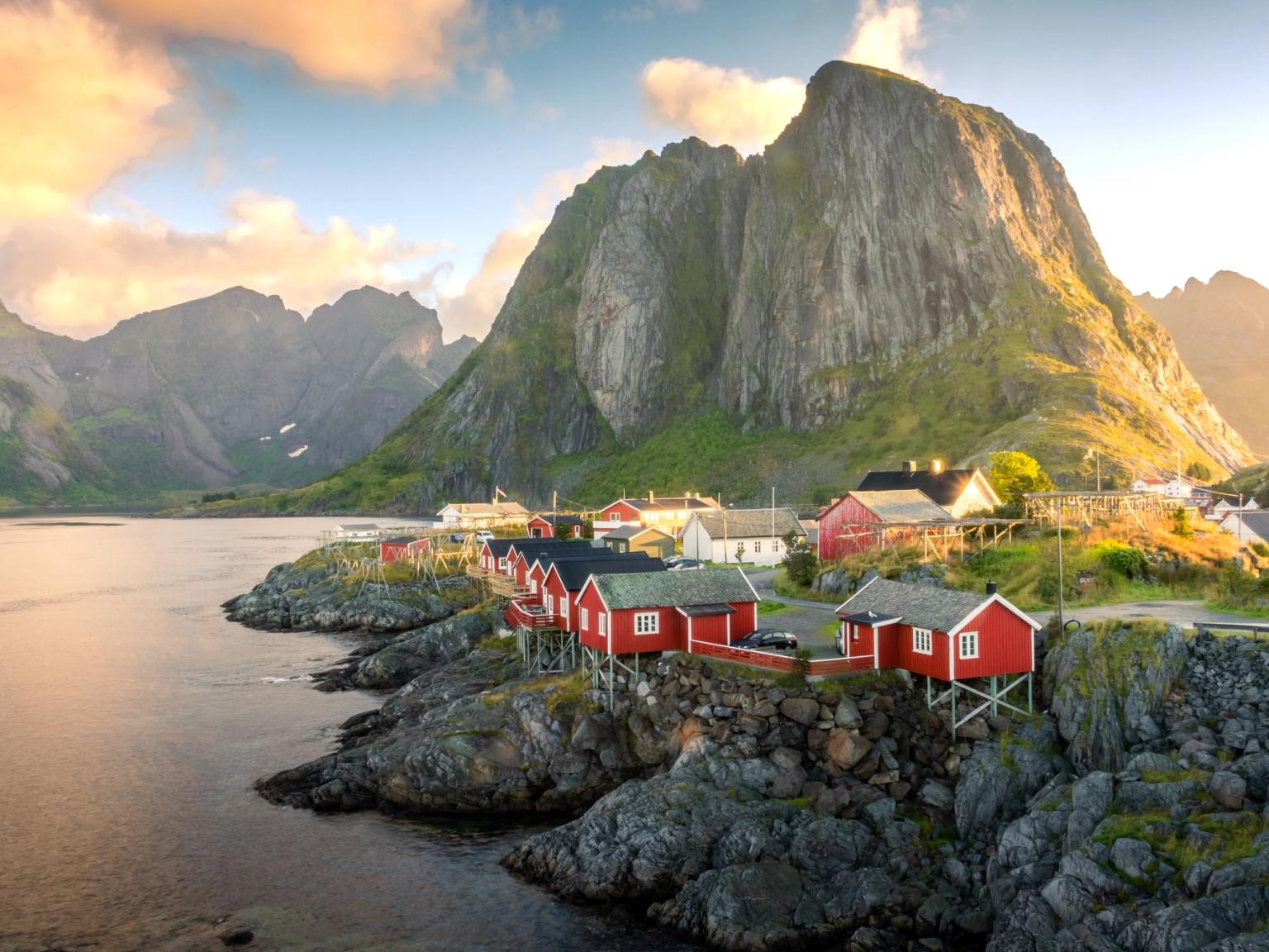 a small village in the mountains with red houses and a mountain in the background