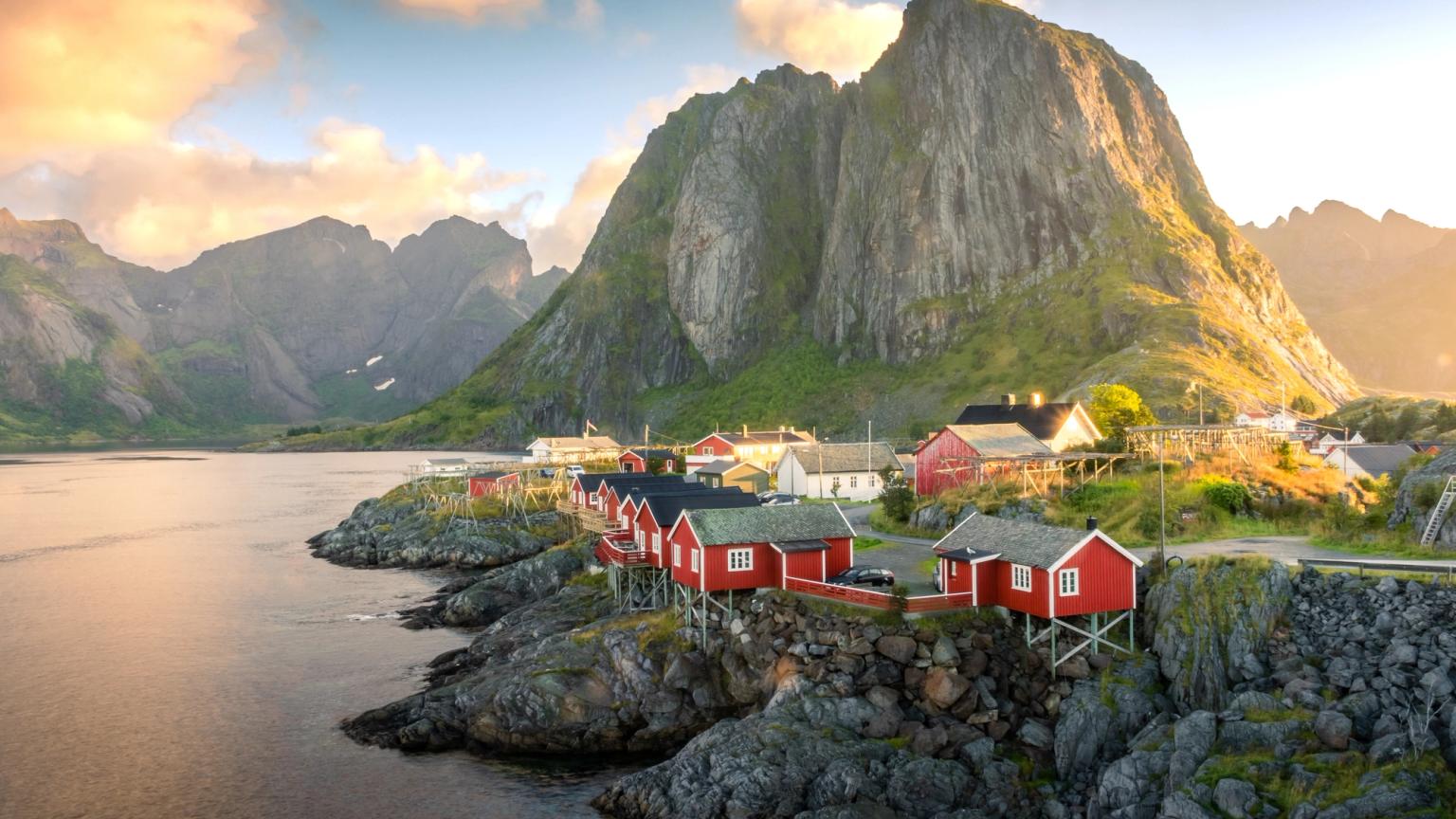 a small village in the mountains with red houses and a mountain in the background