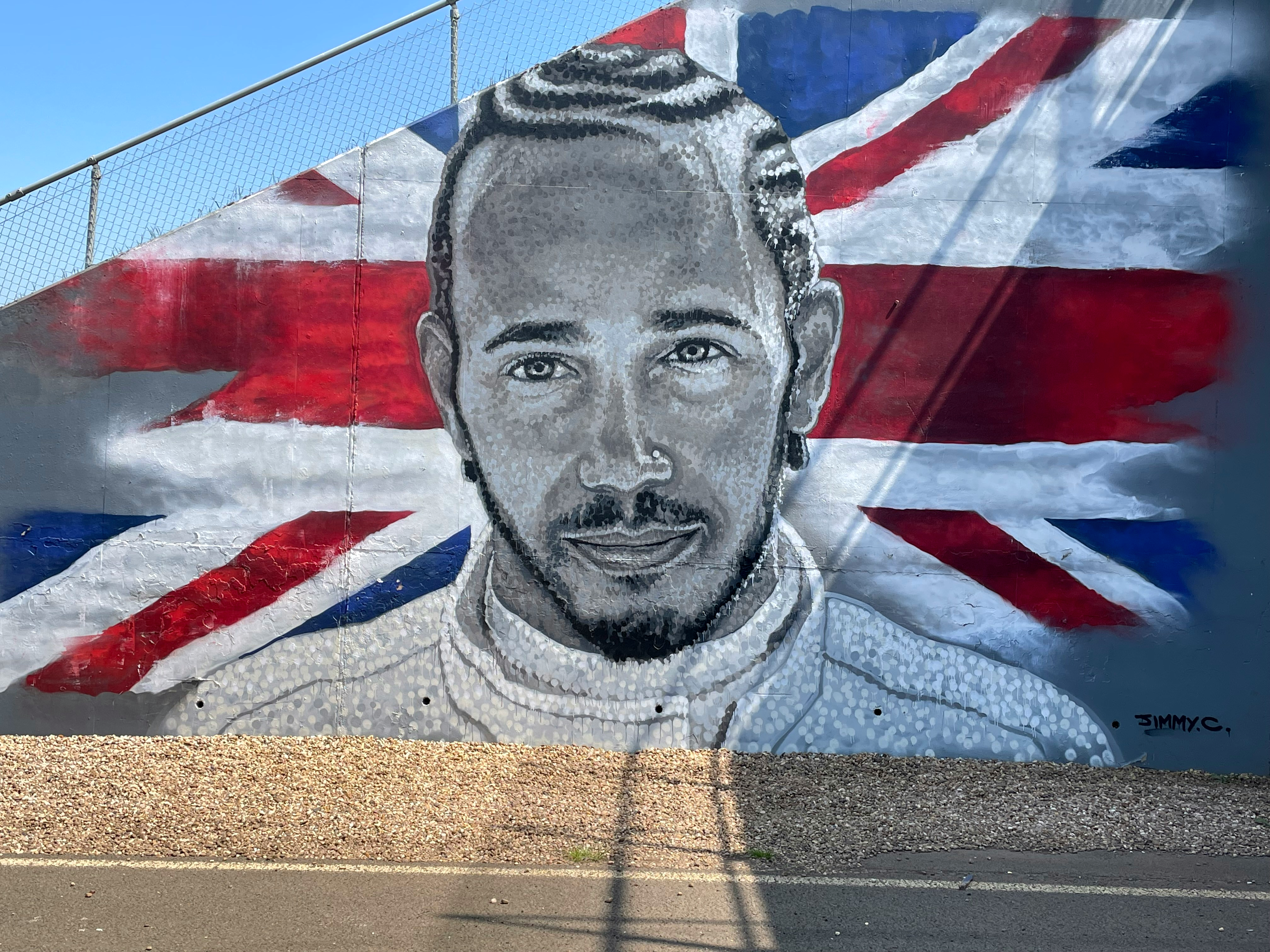Mural of Lewis Hamilton in grayscale against a British Union Jack flag.