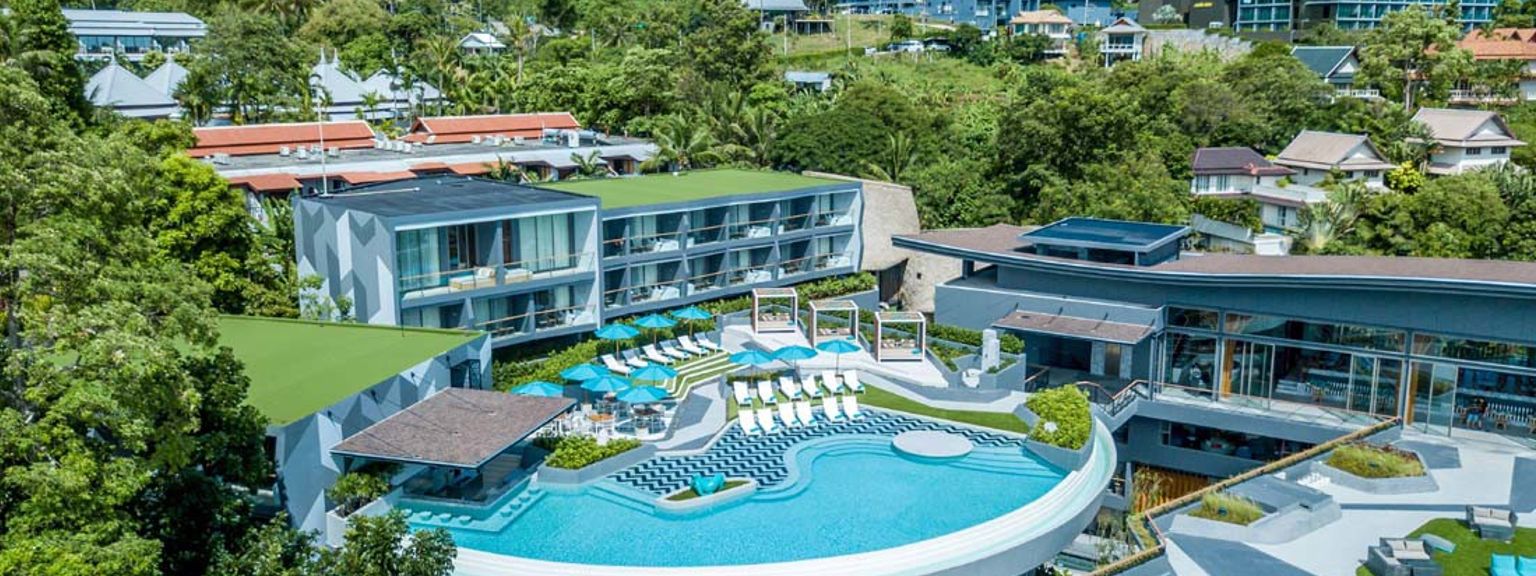 en luftig utsikt over et stort svømmebasseng omgitt av bygninger og trær