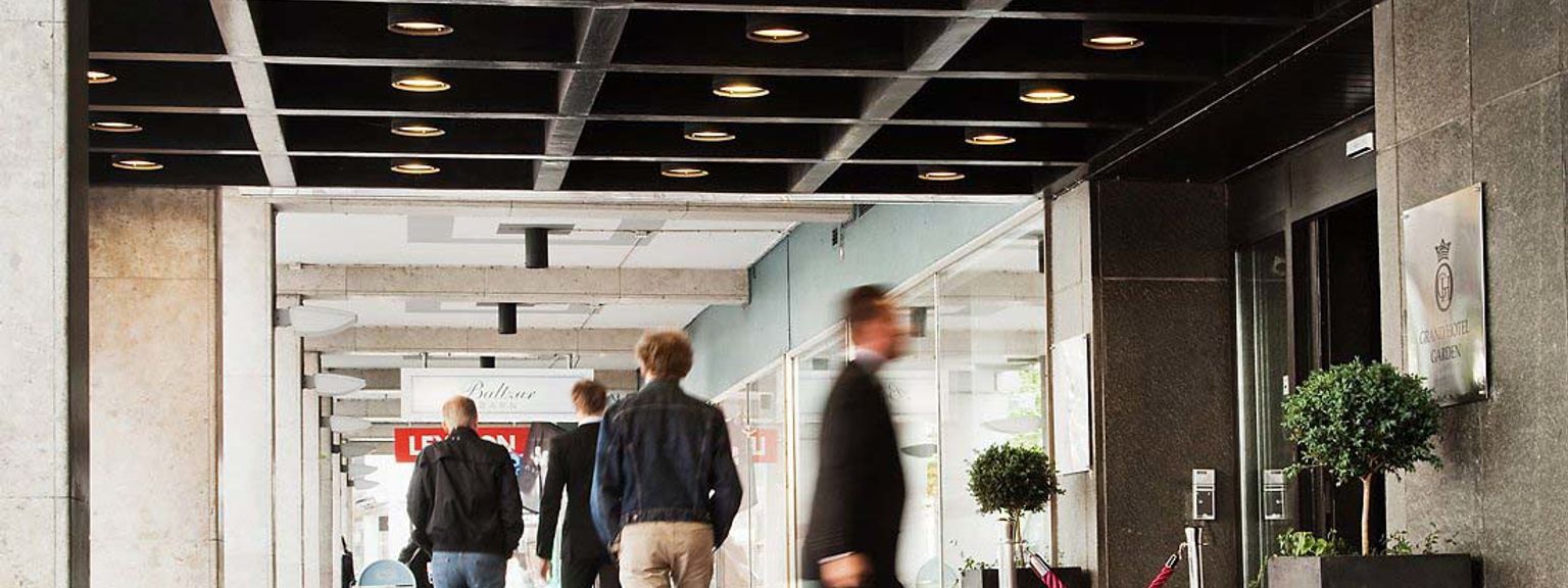 en grupp människor går nerför en röd matta framför Grand Hotel Garden.