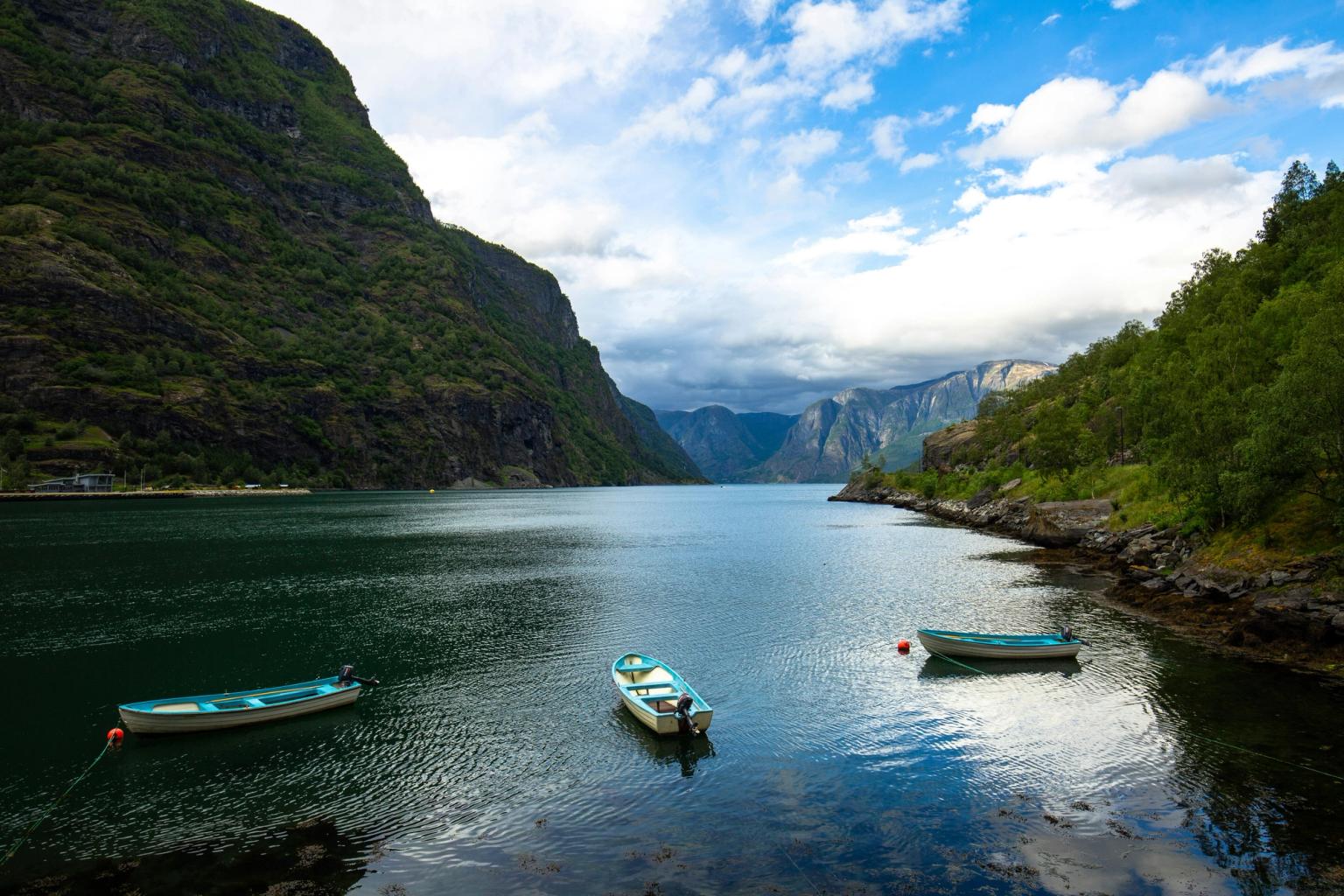 two boats are floating on a lake surrounded by mountains