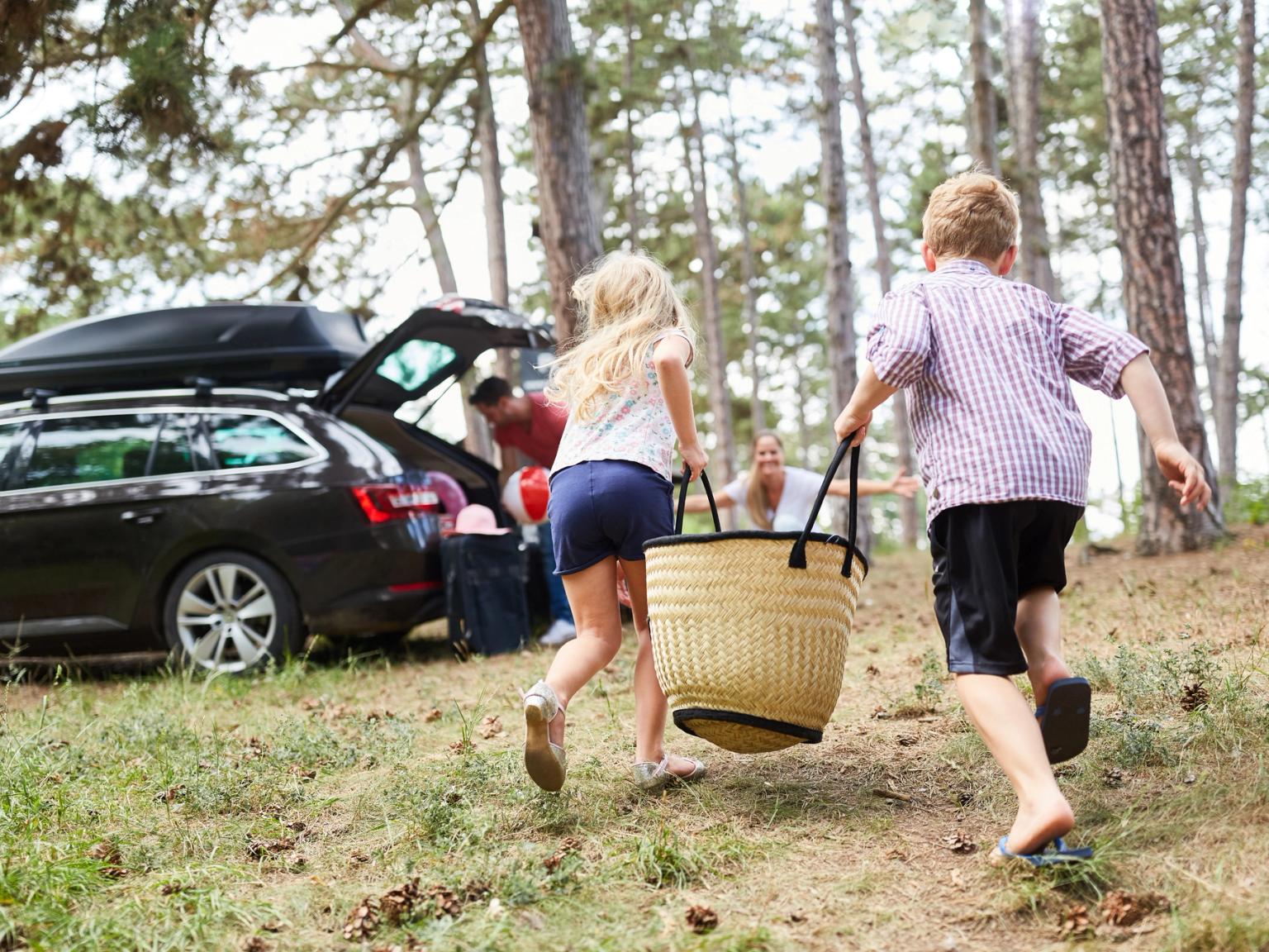 en gruppe barn løper mot en bil med en piknikkurv