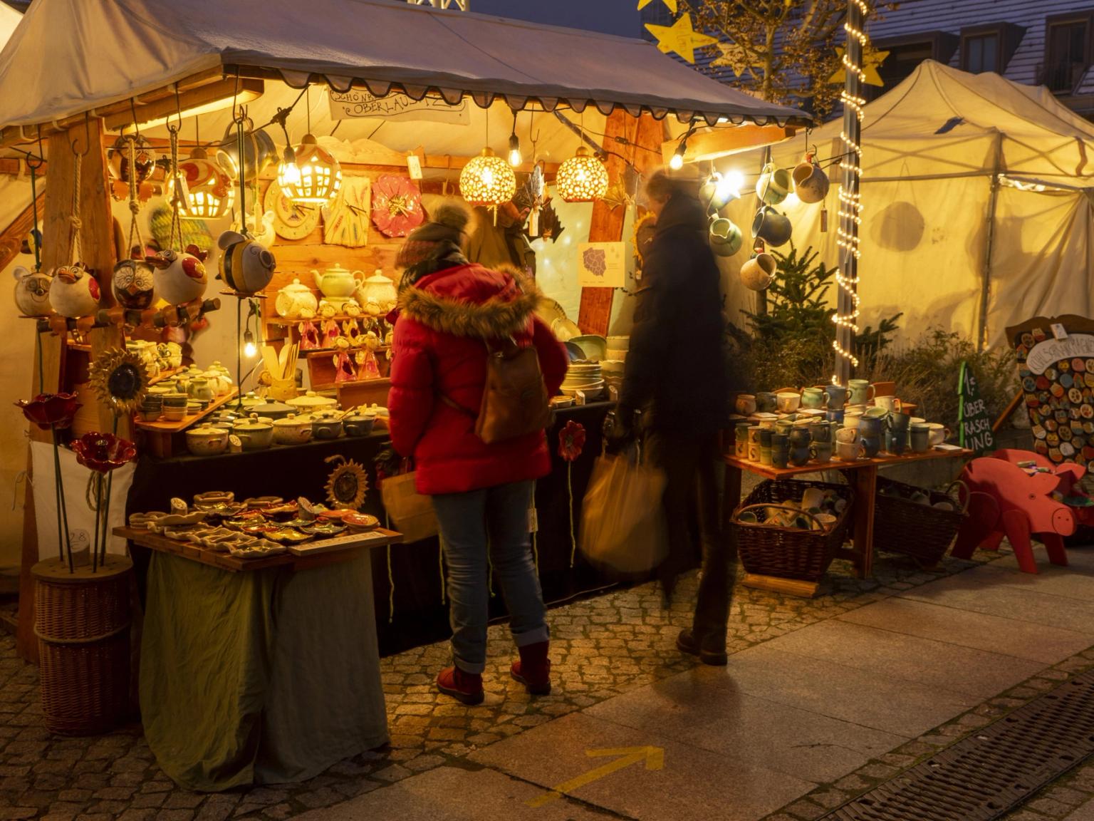 en grupp människor shoppar på en julmarknad
