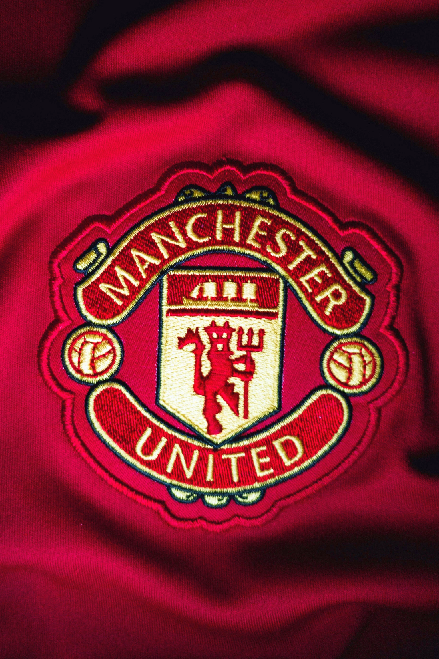 Brodert Manchester United-merke på en rød trøye.