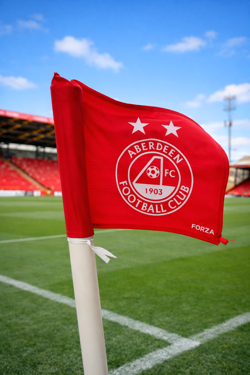 Et rødt Aberdeen FC hjørneflag står på en fodboldbane på et stadion.